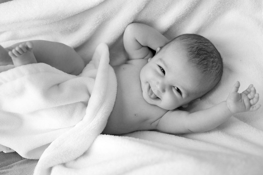 Bébé enveloppé calme et souriant, après un massage